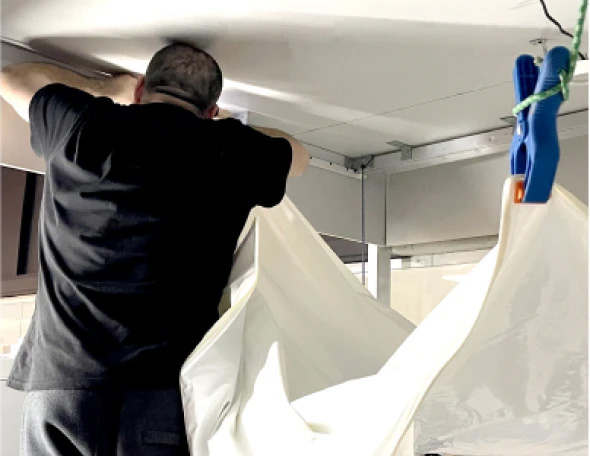 Крепление полотна. Натяжной потолок по углам закрепляют на зажимы и частично заправляют в багет